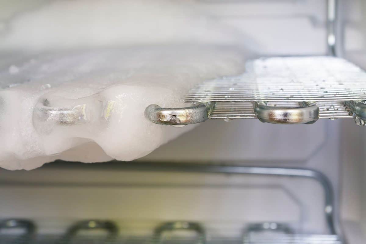 A freezer being defrosted with ice building up on the trays