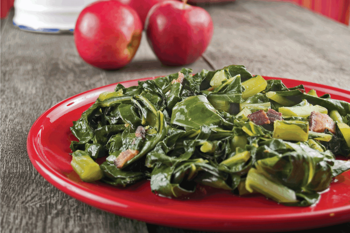 Collard greens & bacon on a red plate and wooden table