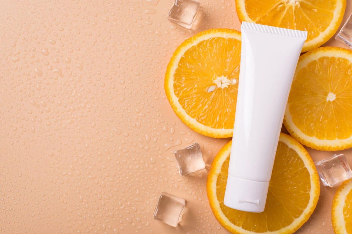 Top above overhead close up view photo of a sunscreen lying on slices of orange fruit