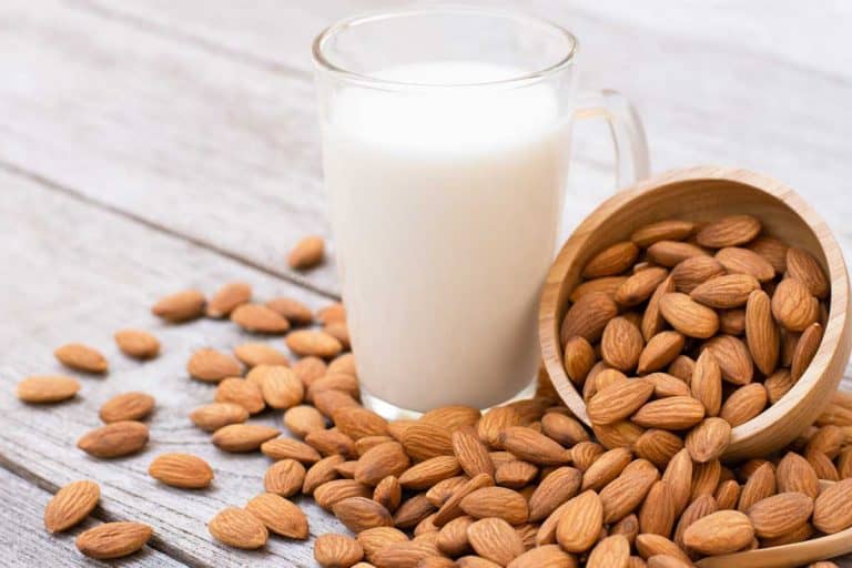 Almonds nuts in wooden bowl and almond milk in glass on wood table background, Can You Freeze Almond Milk To Make Ice Cream?