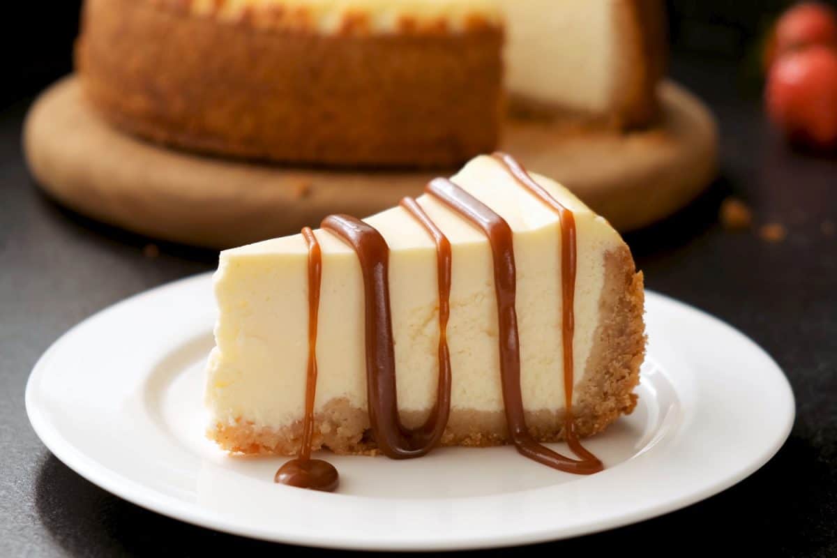 Cheesecake with caramel sauce on black background