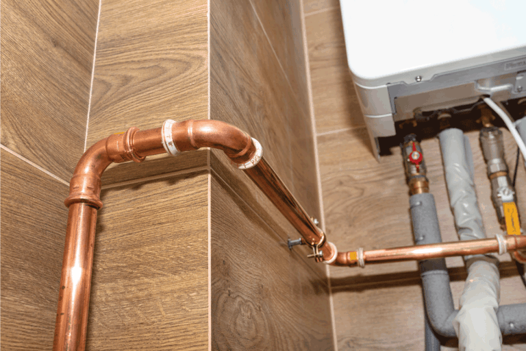 Copper pipes for natural gas installations, attached to a wall in a boiler room lined with ceramic tiles. Do Gas Pipes Freeze In Cold Weather