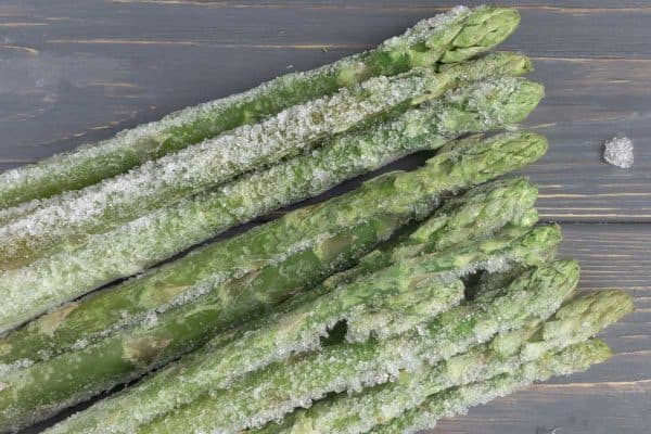 Frozen asparagus on a wooden surface, Can You Freeze Asparagus? [Including After Cooking]