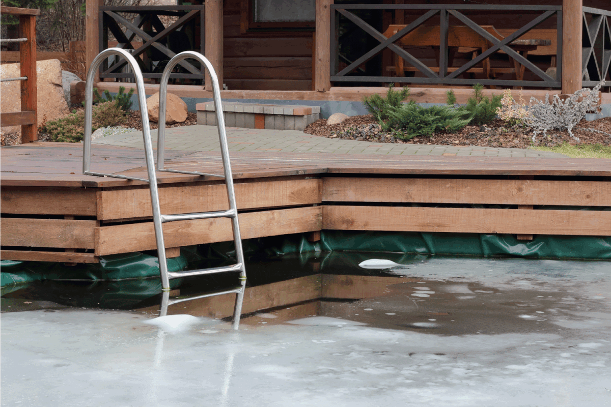 frozen pool with wooden boardwalk and metal ladder