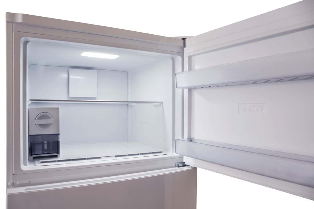 A freezer door left opened on a white background
