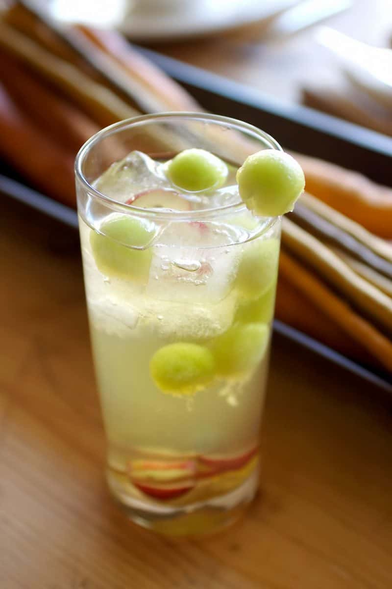 A small glass of sparkling water with green grapes on it