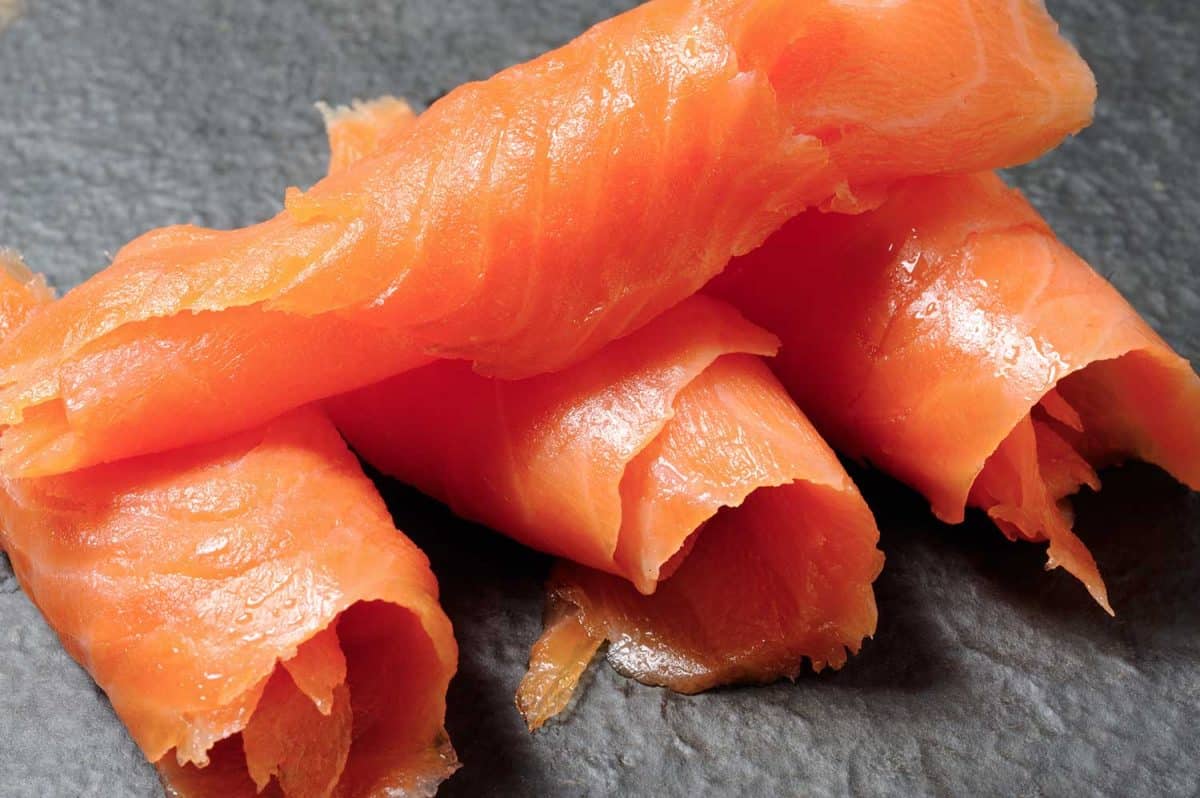 Close-up of rolls of smoked salmon on a gray background