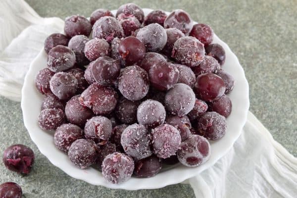 Frozen grapes on a small white plate, Does Freezing Grapes Make Them Sweeter?