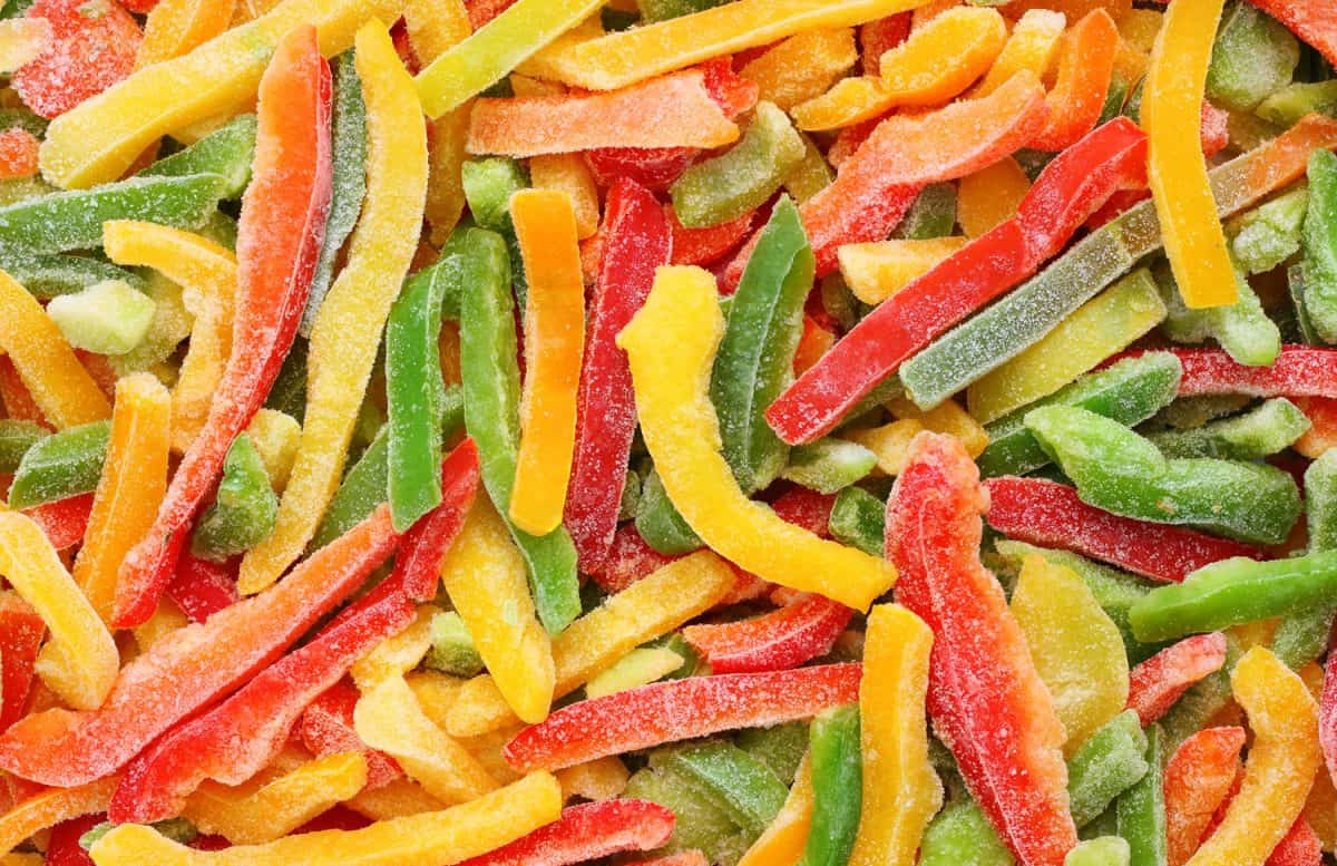 Frozen multicolored peppers background, ready to stir-fry


