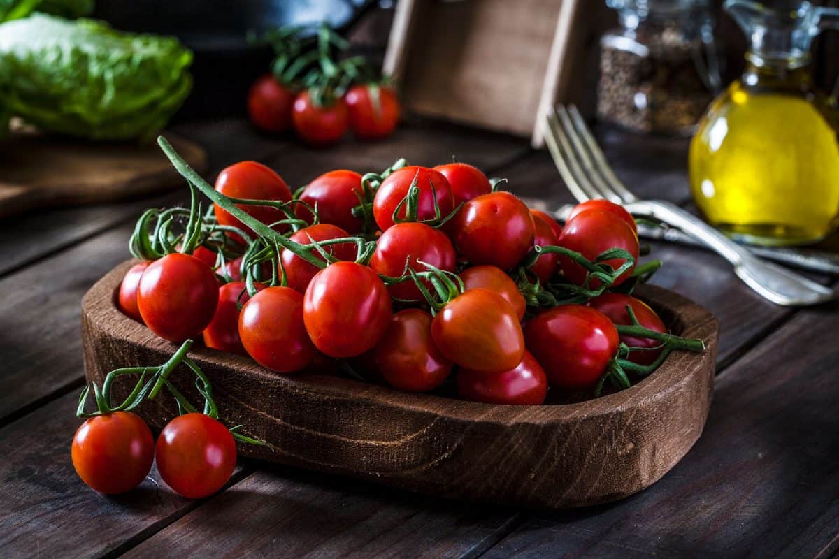 Red cherry tomatoes on a wooden tray