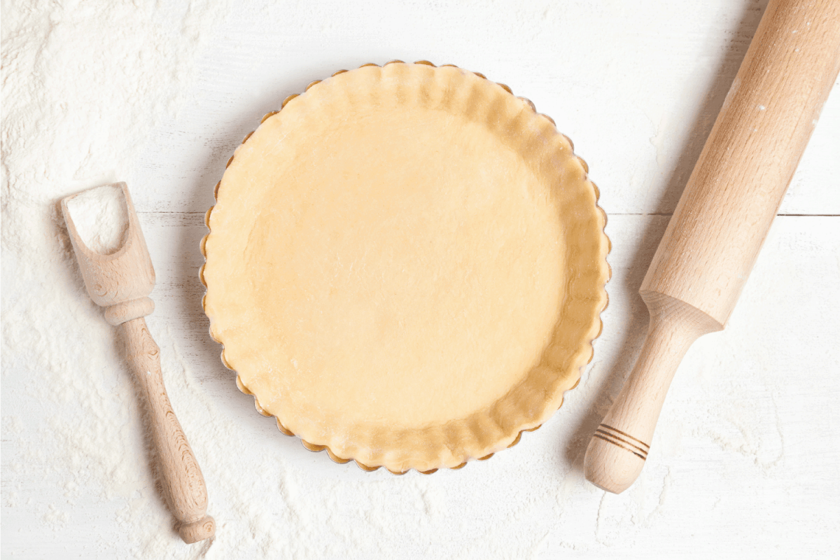 Tart pie preparation, dough with yeast and rolling pin on white kitchen table
