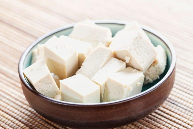 cubes of Tofu, marinating in a small bowl,, How Long Does Tofu Last In The Freezer?