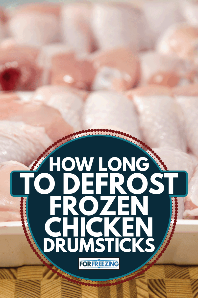 frozen Chicken drumsticks stacked in a container on wooden cutting board. How Long To Defrost Frozen Chicken Drumsticks