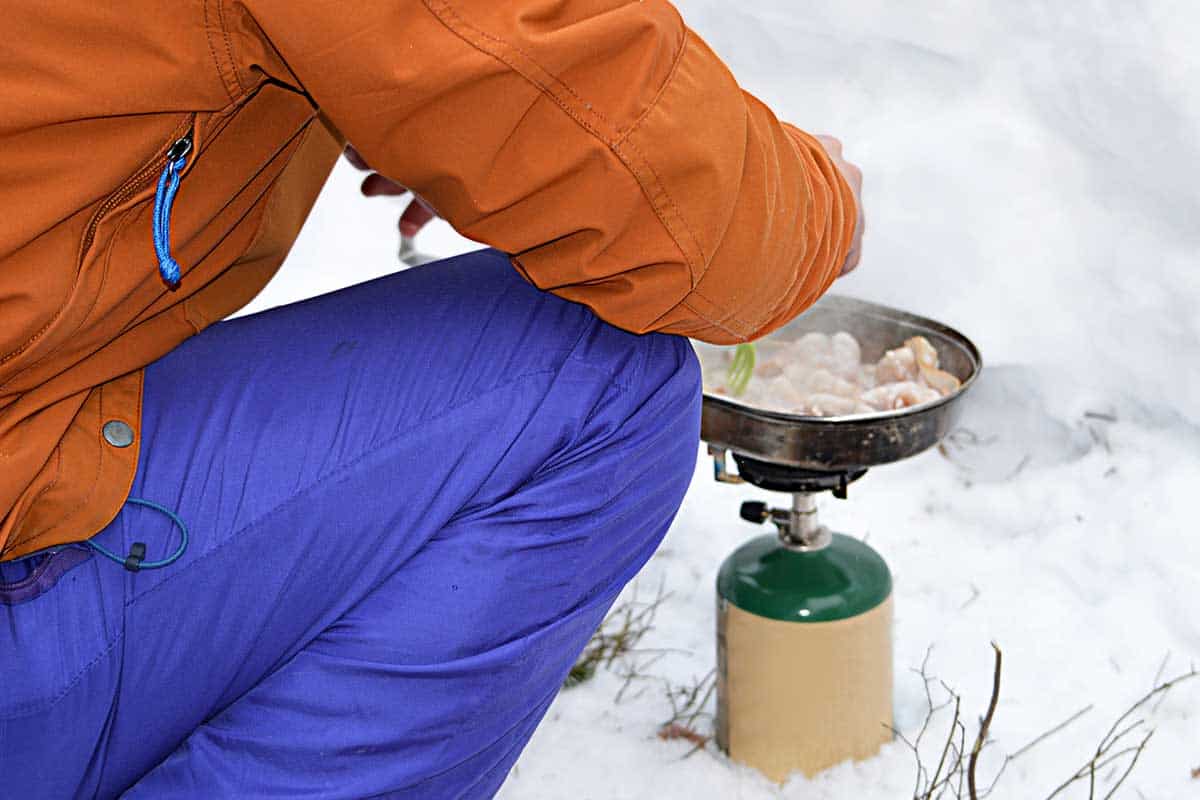 Camper cooking on a butane canister stove on a winter camping trip, What Happens If Butane Freezes?