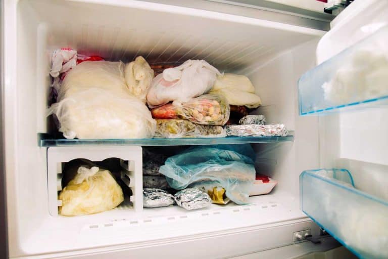 Opened freezer with frozen food inside, What To Store In A Freezer Door