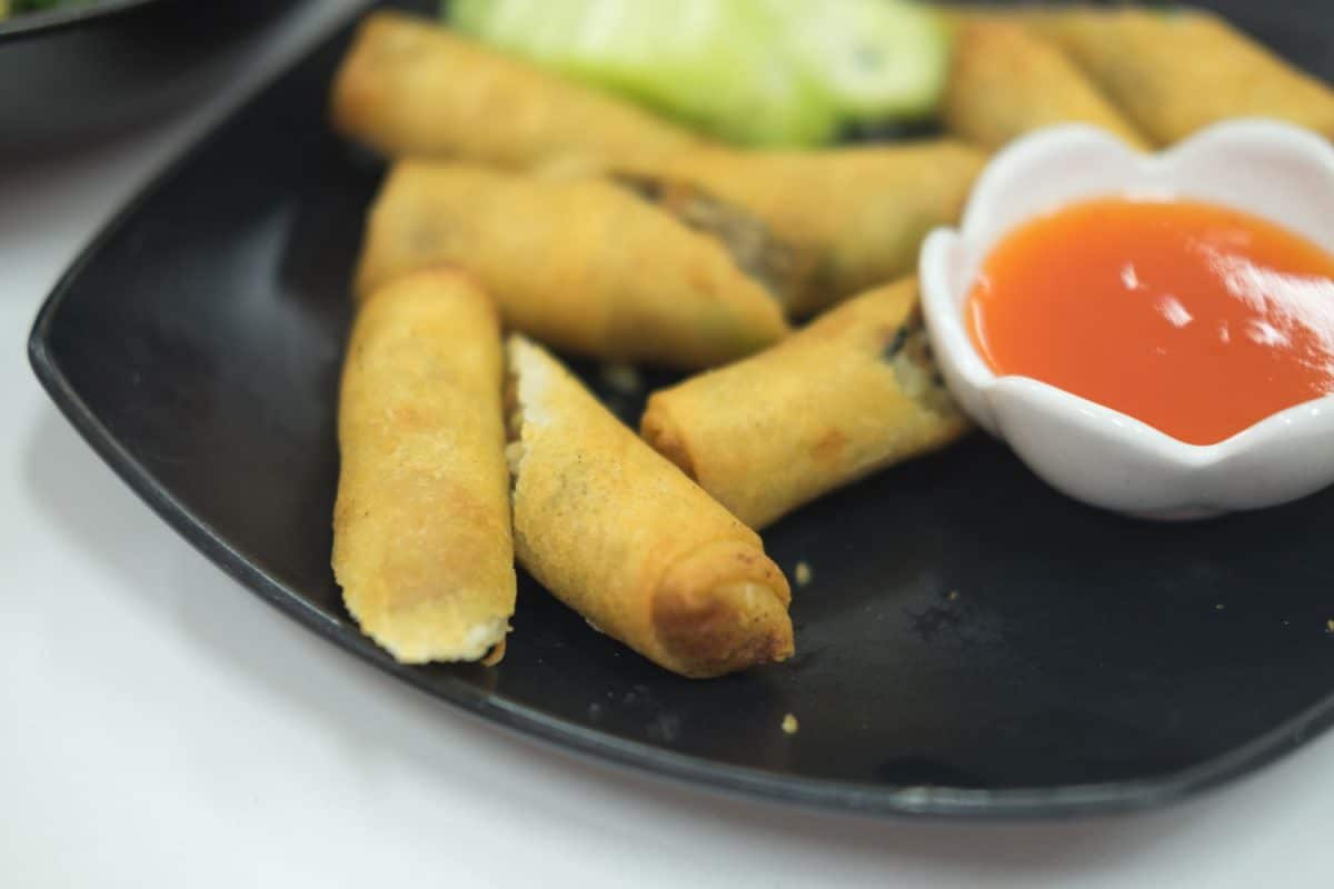 Sliced egg rolls with a sauce on the side