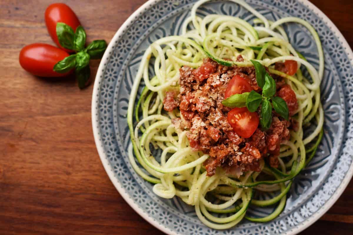 Zucchini noodles called zoodles with vegan bolognese and yeast flakes – vegan, healthy food