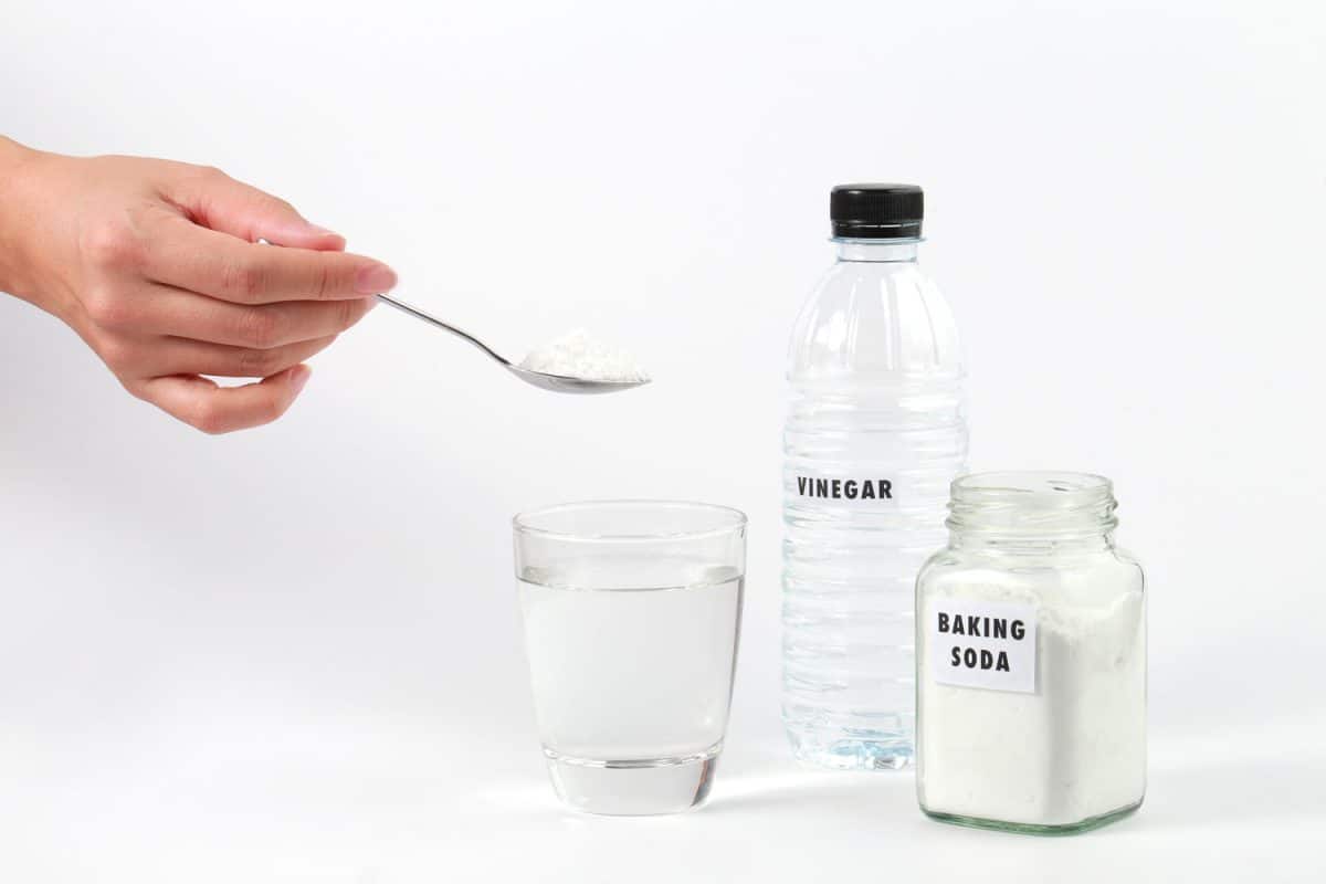 A woman making an effective cleaning mix using vinegar and baking soda