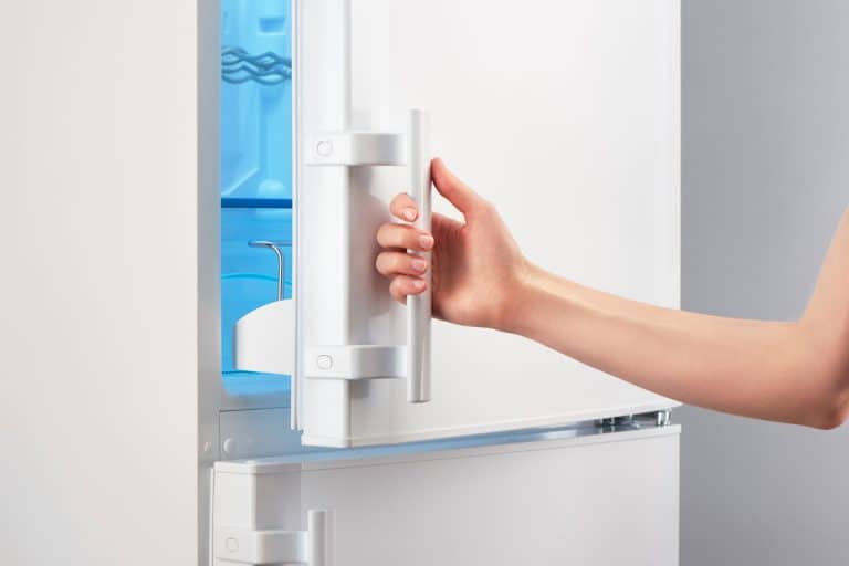 A woman opening the freezer door, Freezer Door Won't Open All The Way - What To Do?