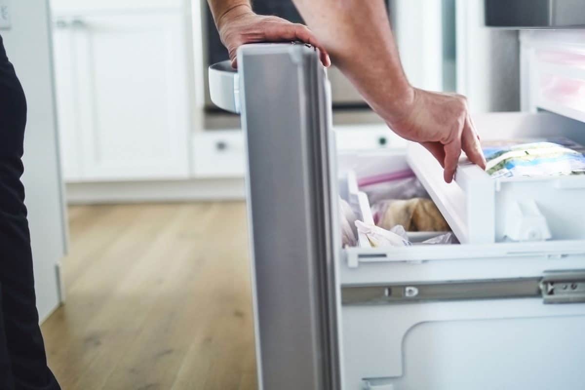 A woman grabbing something inside her freezer