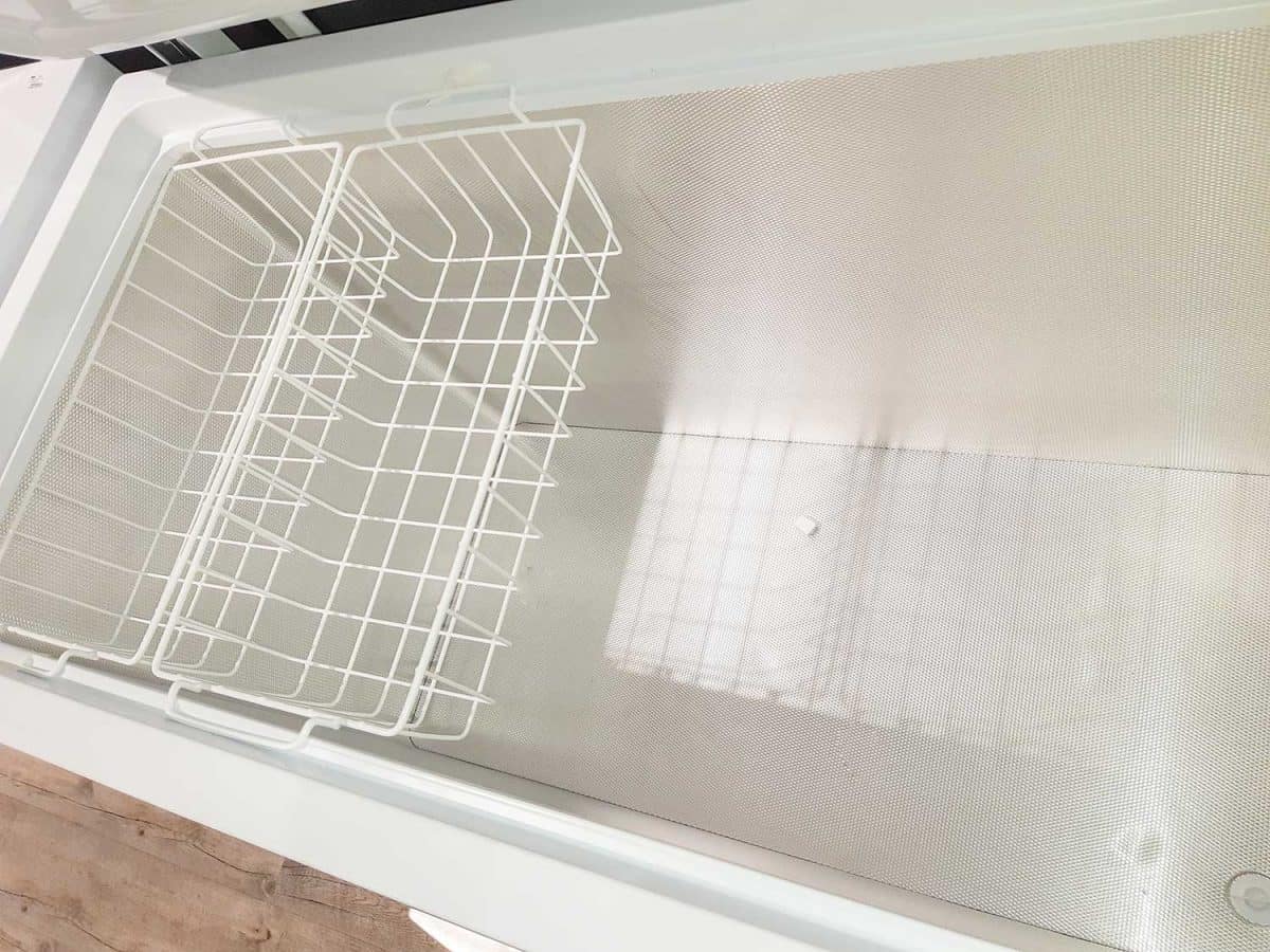 Empty chest freezer interior with open door