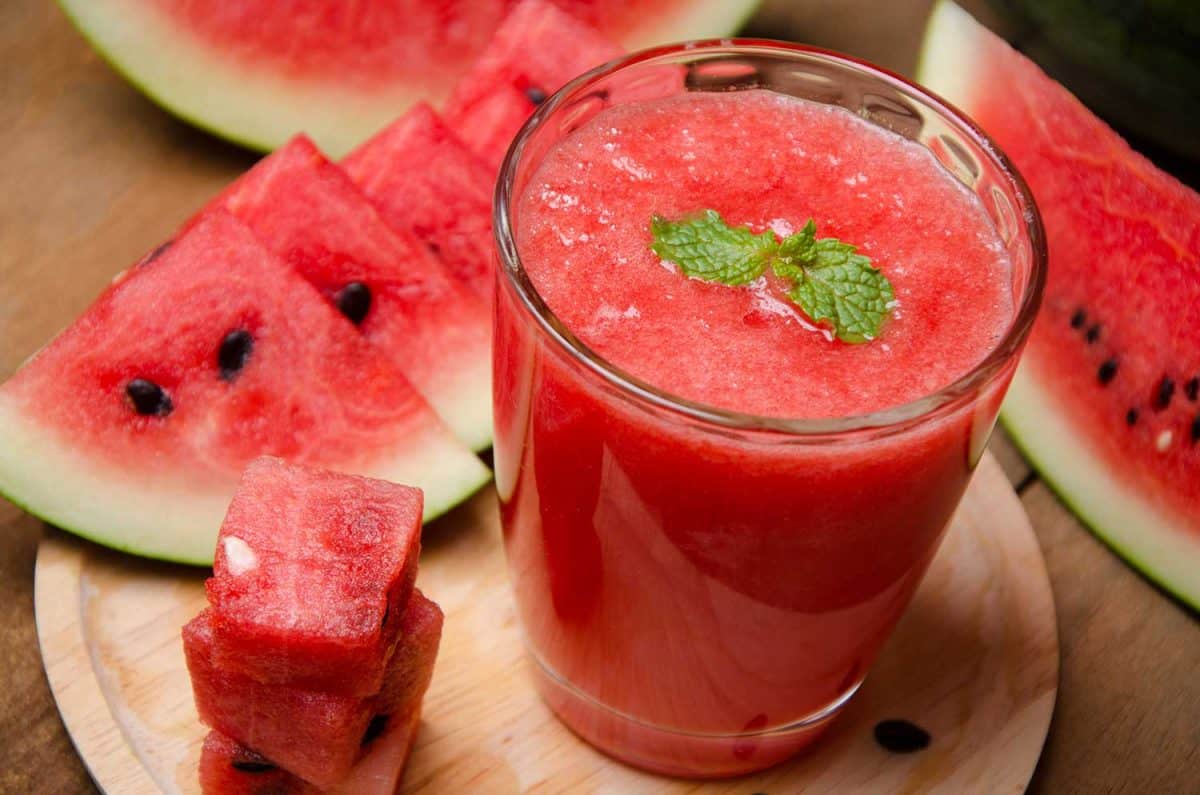Watermelon smoothie and watermelon slices on wooden table