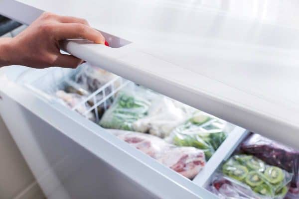 Woman hand opening a chest freezer door, How To Quickly Defrost A Chest Freezer
