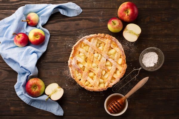 Homemade-autumn-apple-pie-with-fresh-apples,-spices,-honey-and-cinnamon-on-dark-rustic-wooden-background
