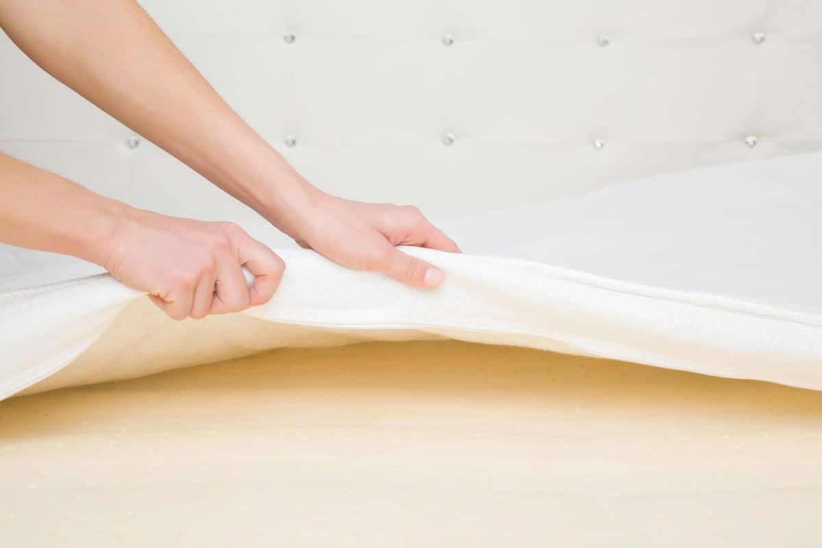 A woman placing a memory foam mattress