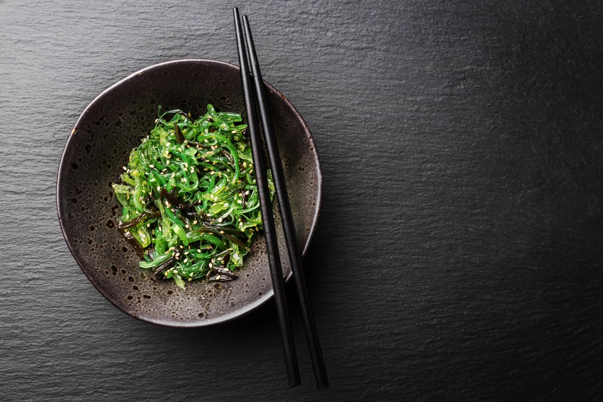 A small bowl of healthy seaweed salad drizzled with sesame seeds