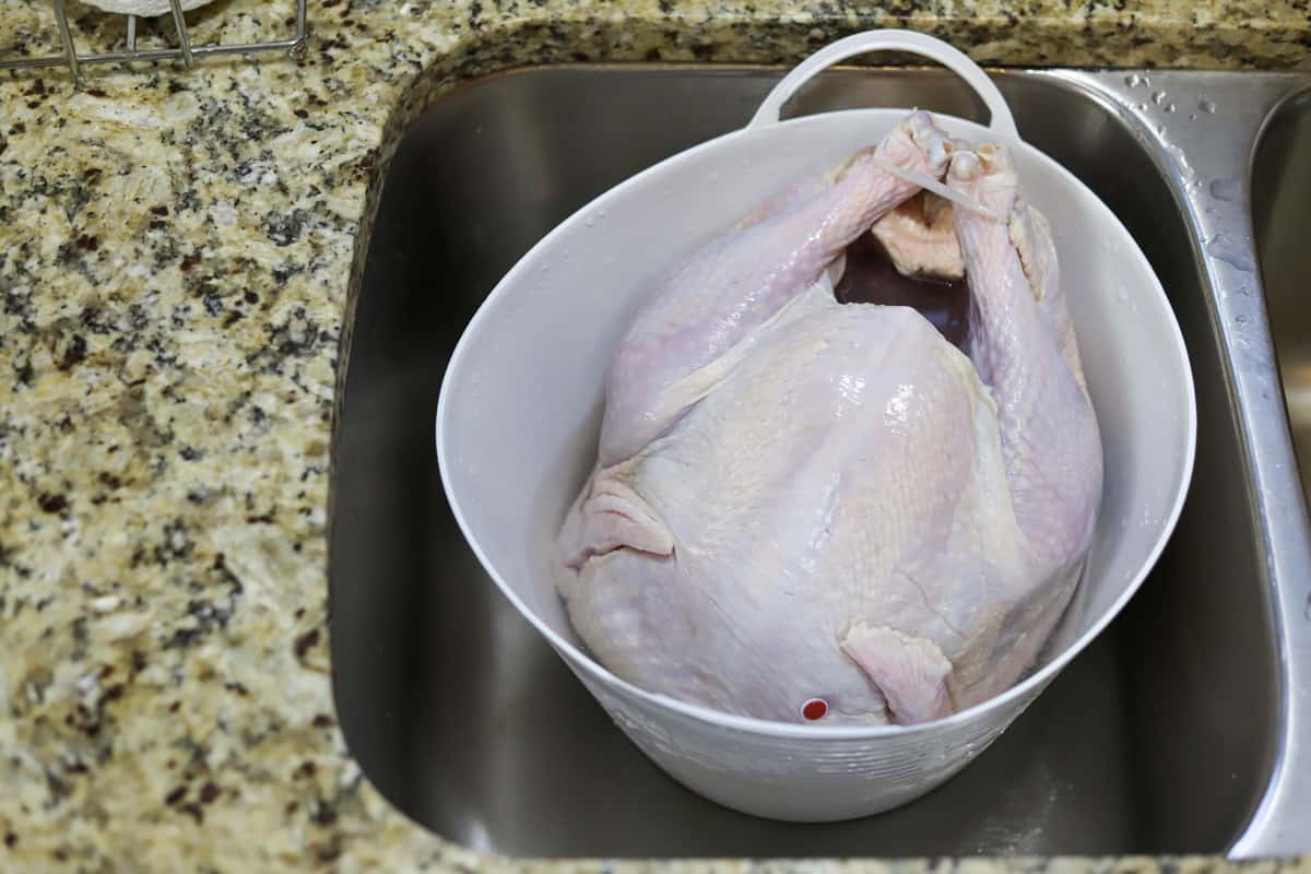 Putting chicken in a pot filled with water to defrost it faster