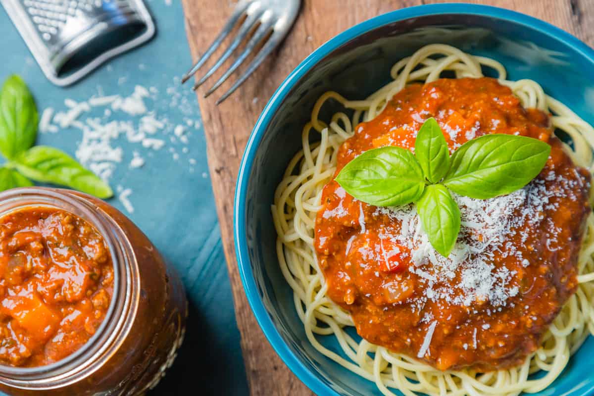 Bolognese sauce, spaghetti, pasta, meat, cheese, basil.