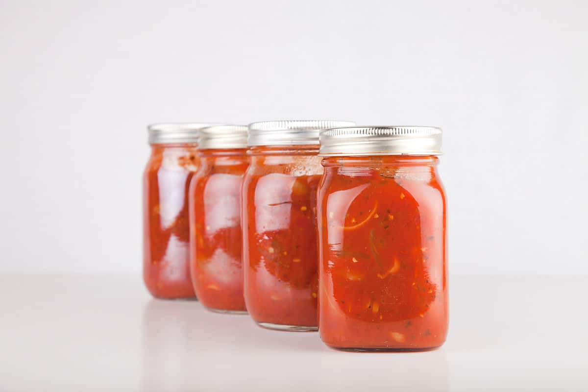 Jars of tomato sauce on a white surface. Cans of spaghetti sauce isolated on white background.