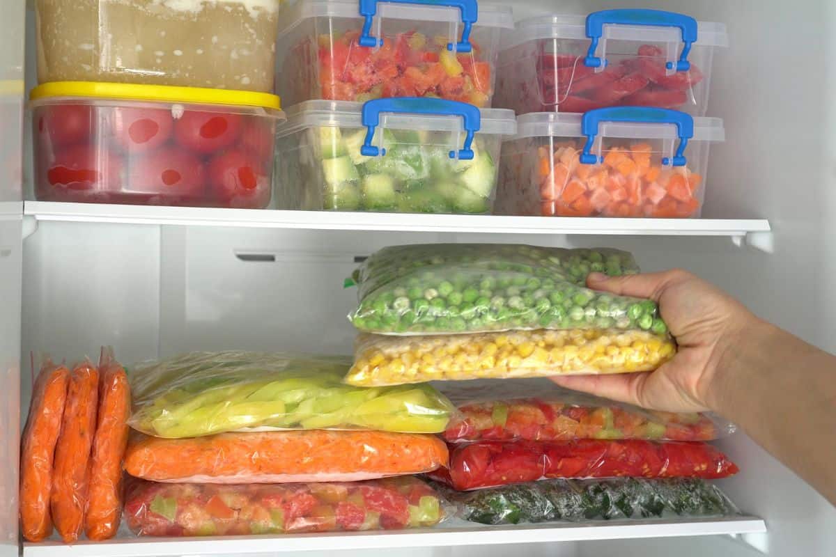 Deep Freezer. Packages and containers with frozen fruits and vegetables. Food storage