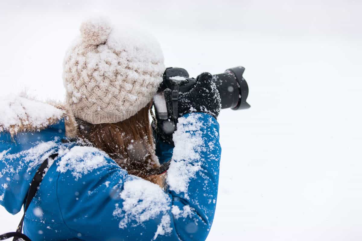 Woman taking photo of the icy landscape using her camera