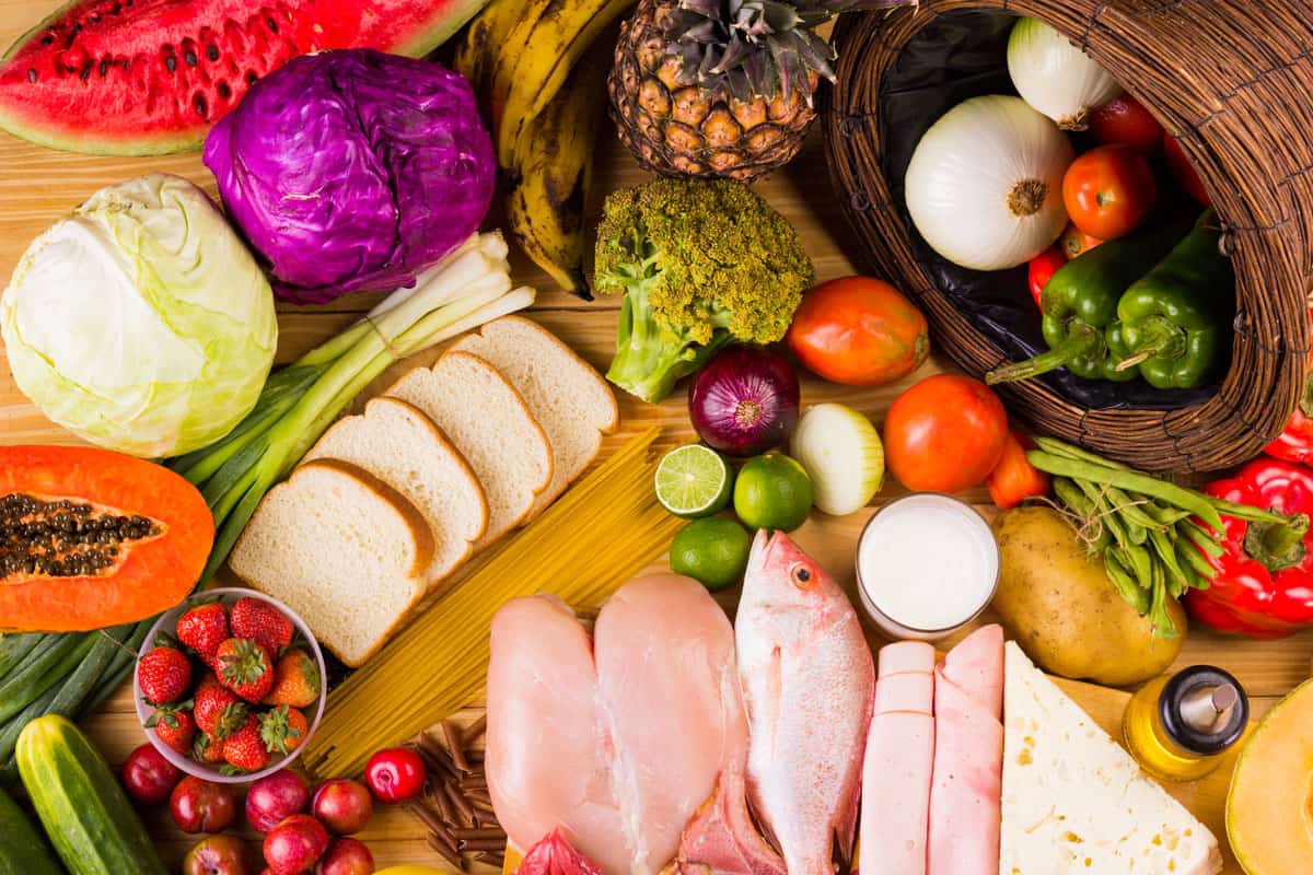 table full of all kinds of food in our daily diet includes proteins, carbohydrates, fats, vegetables and fruits