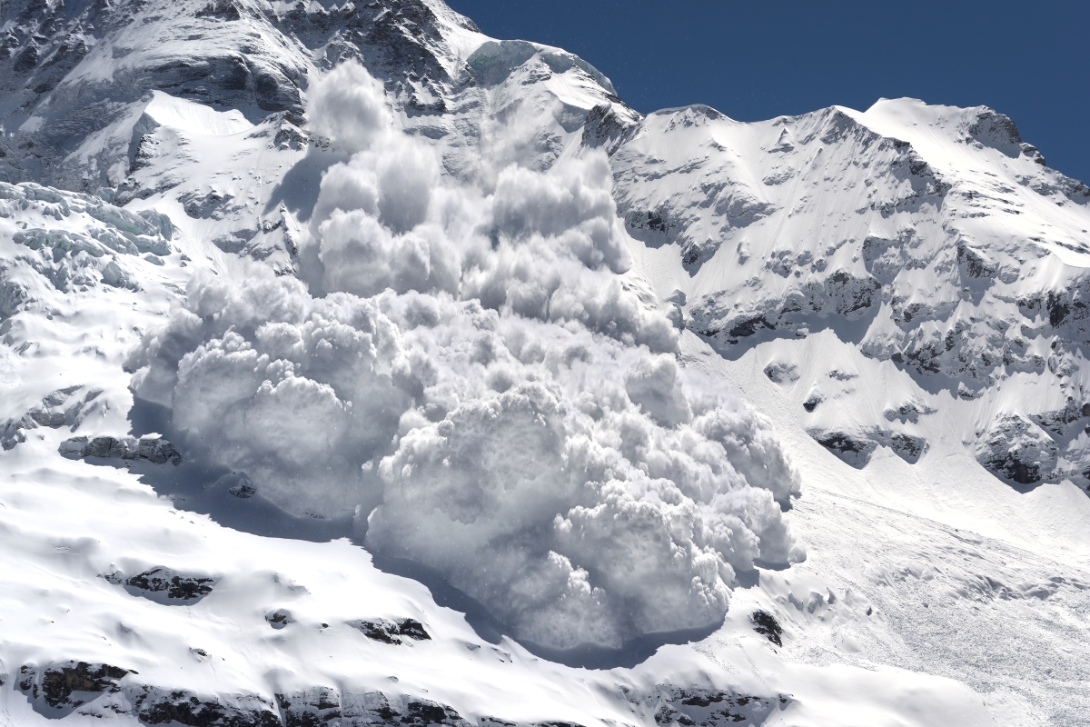 An avalanche is rumbling down a steep mountain slope